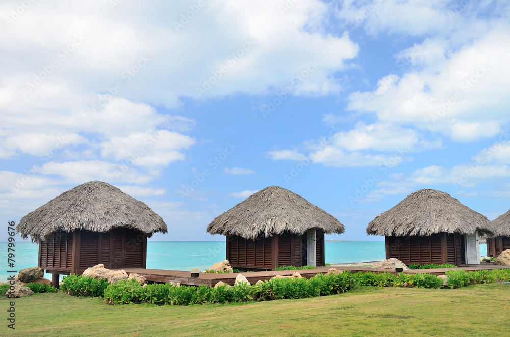 Bungalows in front of turquoise sea.