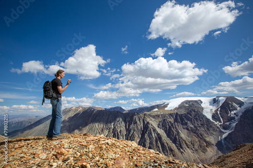 Man with video camera in the mountains