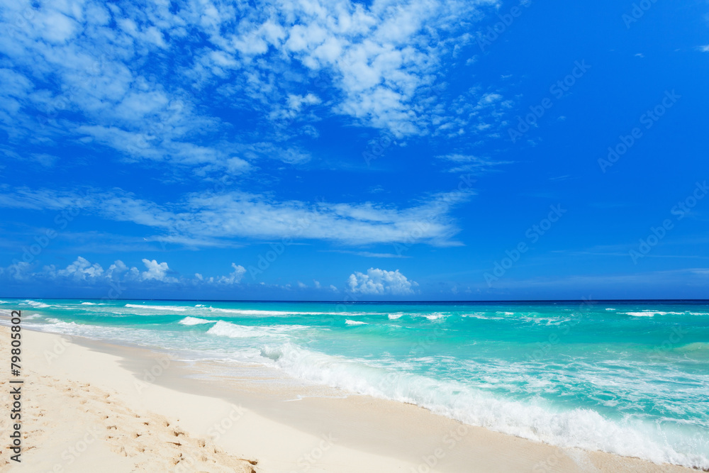 footsteps on white sand and beautiful waves Cancun