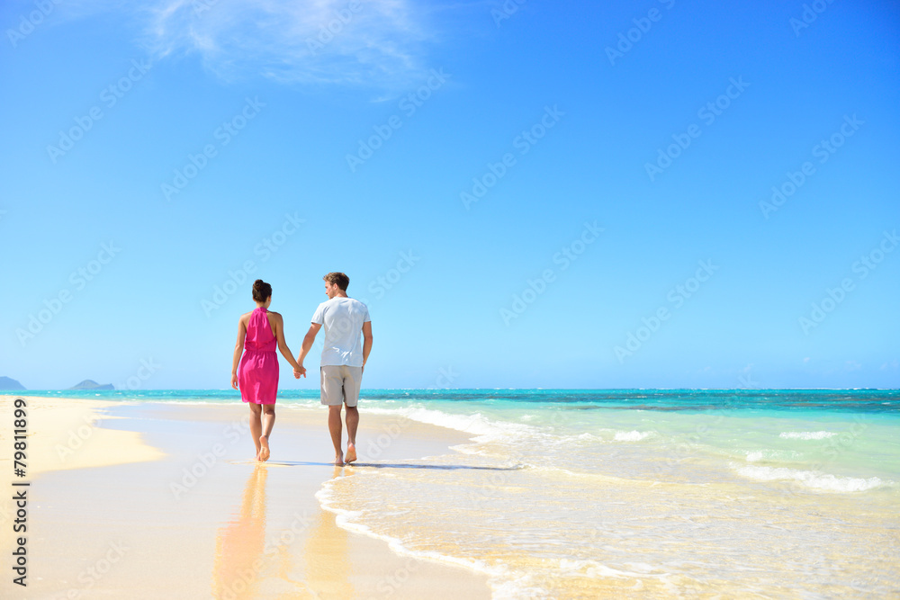 Beach couple holding hands walking on honeymoon Beach couple holding hands walking on honeymoon