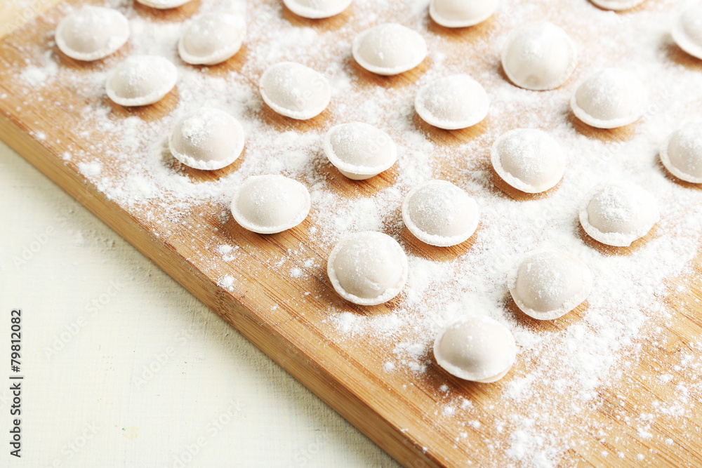 Raw dumplings on cutting board on table close-up Raw dumplings on cutting board on table close-up