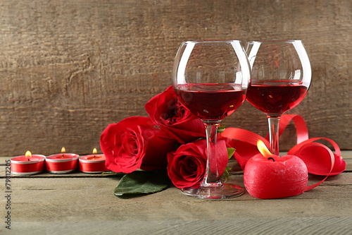 Composition with red wine in glasses, red roses and decorative