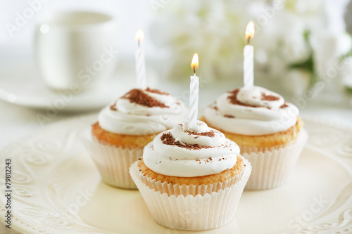 Canvas Print Delicious birthday cupcakes on table on light background