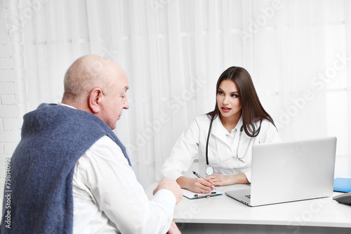 Young female doctor receiving patient in her office