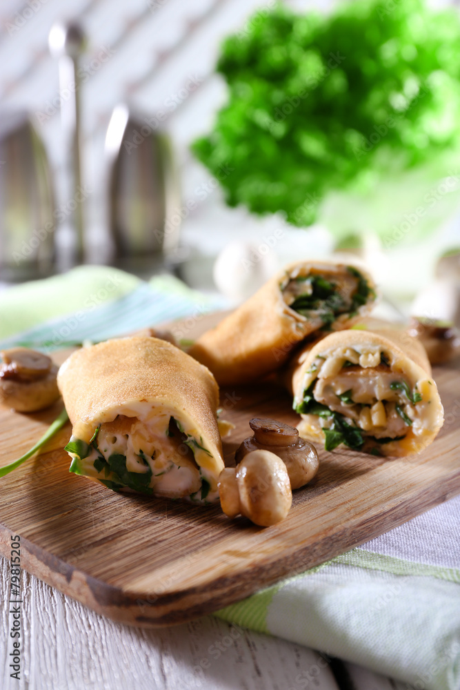 Pancakes with cream and mushrooms on wooden table, closeup