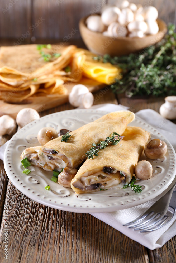 Pancakes with creamy mushrooms in plate on wooden background Pancakes with creamy mushrooms in plate on wooden background