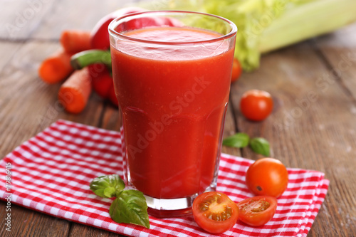 Glass of tomato juice with vegetables on wooden table close up