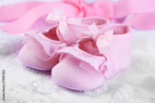 Pink baby boots on cloth close-up