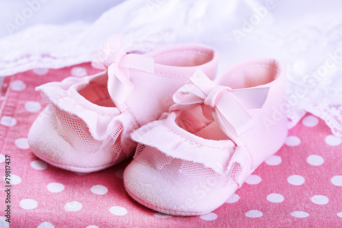 Pink baby boots on cloth close-up