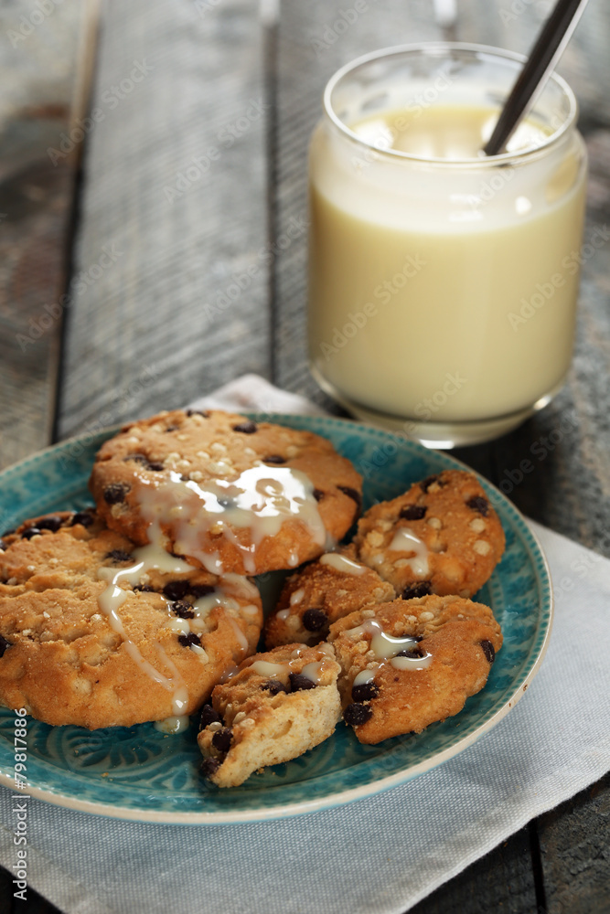 Cookies on plate with jar of condensed milk on wooden Cookies on plate with jar of condensed milk on wooden