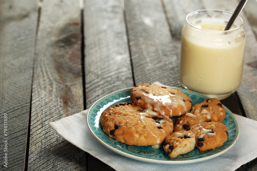 Cookies on plate with jar of condensed milk on wooden Cookies on plate with jar of condensed milk on wooden