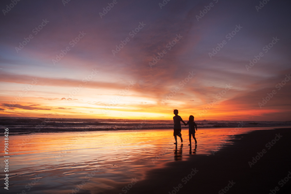 Playful children on beach at sunset time