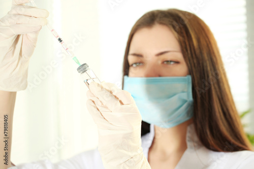 Ampule and syringe in hands of doctor