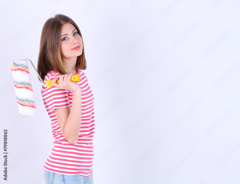 Beautiful girl with roller near wall Beautiful girl with roller near wall