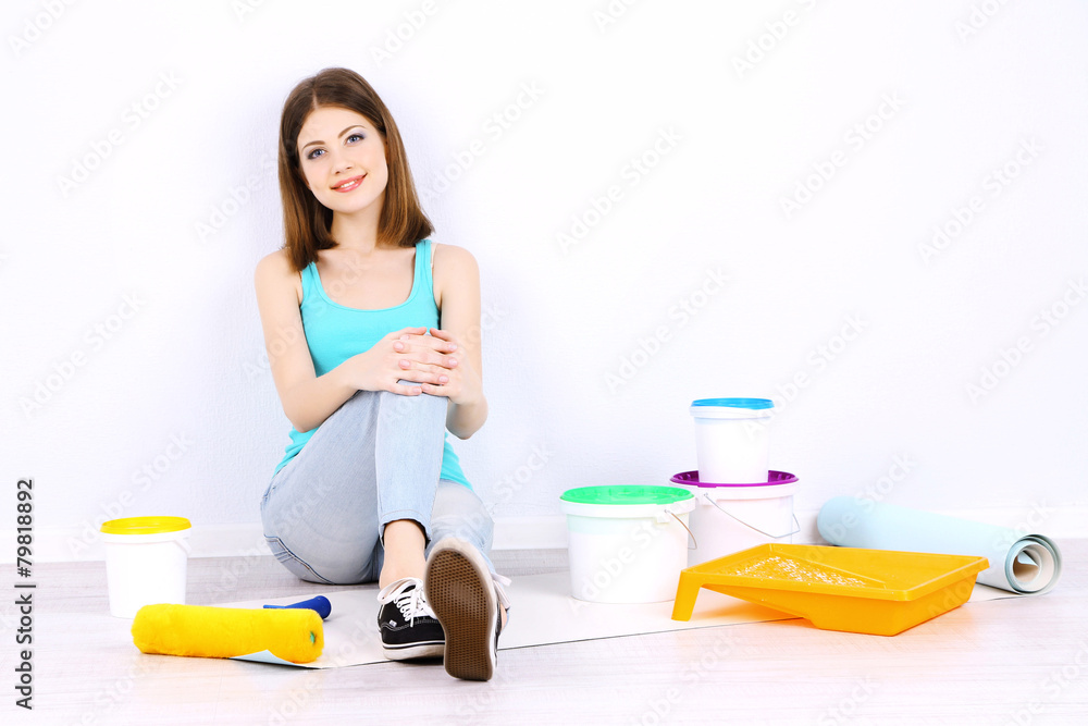 Beautiful girl sitting on floor with equipment for painting Beautiful girl sitting on floor with equipment for painting