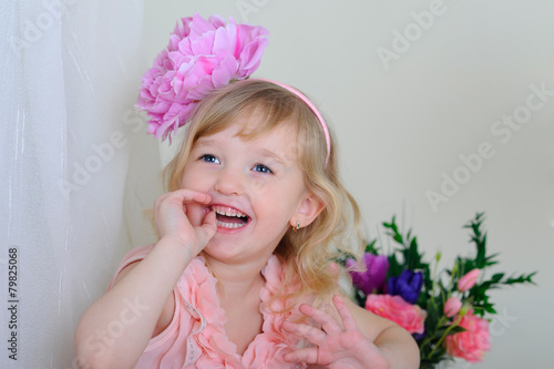 girl with nice teeth flower in her hair and a pink dress laughin