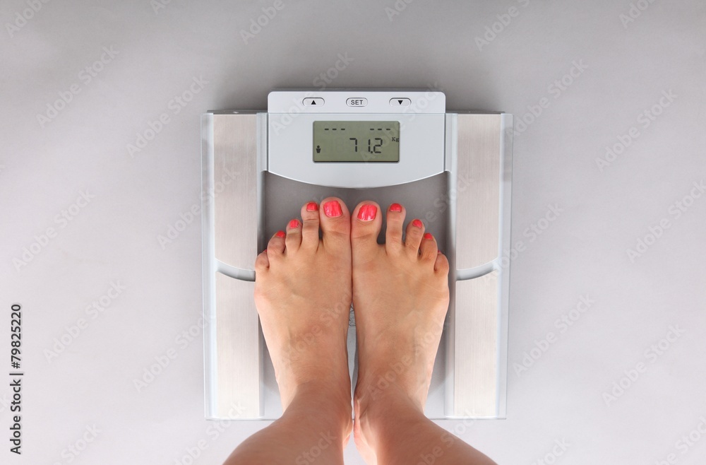 woman on a bathroom scale woman on a bathroom scale