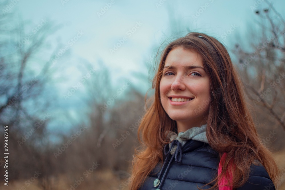 Портрет красивой девушки на фоне ранее весенних горных деревьев