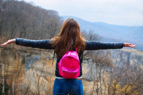Девушка, расправившая руки на фоне прекрасных гор