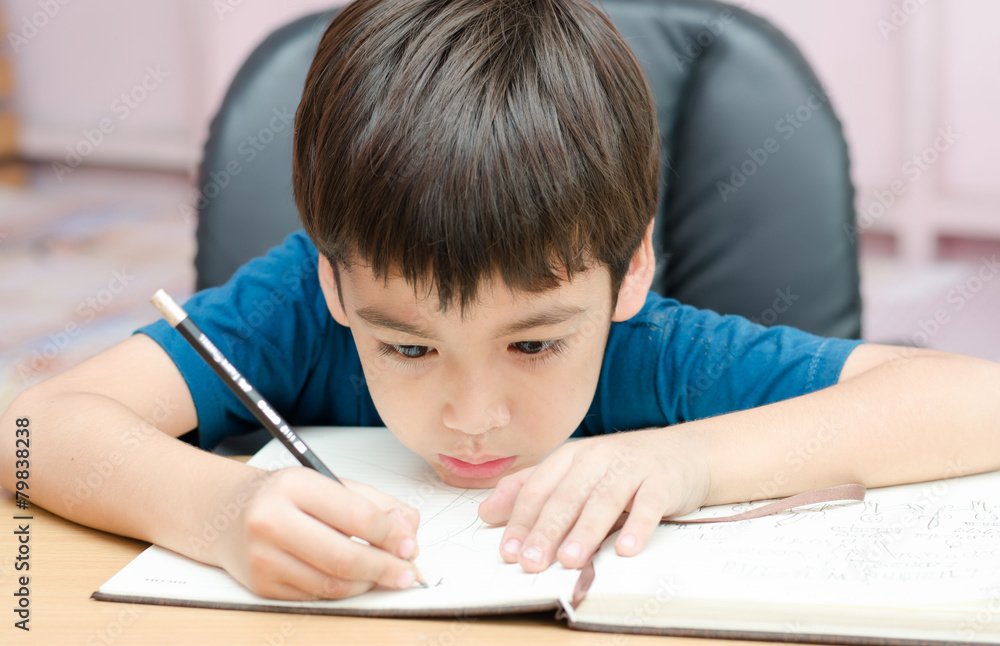 Little boy writing homework in the room Little boy writing homework in the room