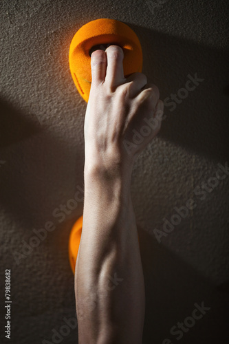 Cropped view of rock climber gripping handhold with two fingers photo