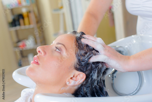 фотографія Hairdresser washing a woman's hair