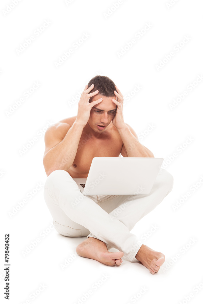 Sad caucasian guy naked chest looking at notebook screen over wh Sad caucasian guy naked chest looking at notebook screen over wh