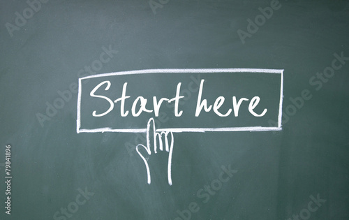 finger click start here symbol on blackboard
