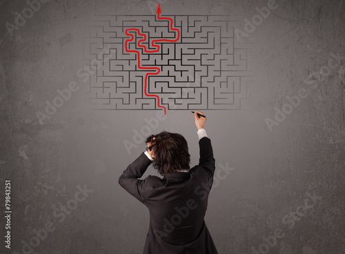 Business man looking at a maze and the way out