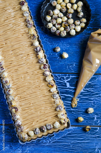 Walnut caramel tart  on a wooden background photo