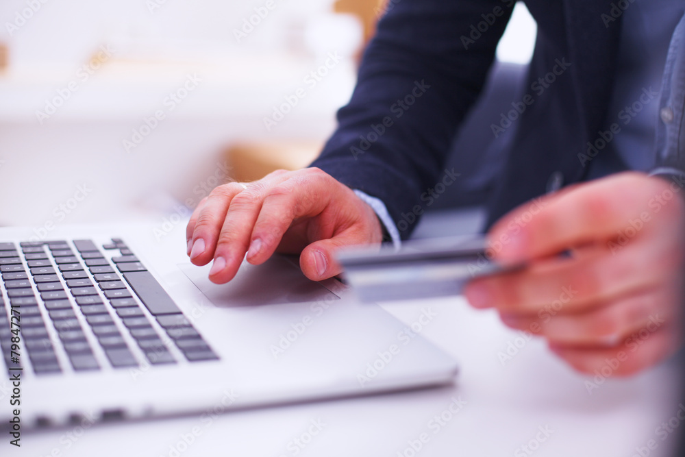 Fototapeta premium Businessman using his credit card for an online transaction