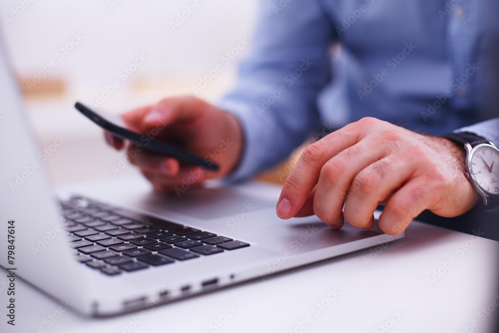 Businessman using laptop and mobile phone Businessman using laptop and mobile phone