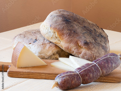 Rustic wholesome produce - artisan bread, salami and cheese. photo