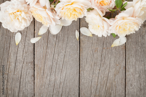Fresh rose flowers on wooden background