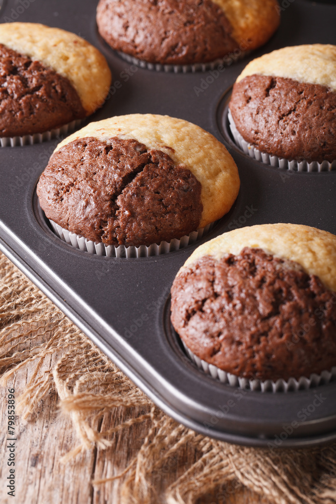 chocolate muffins in baking dish from the oven closeup. vertical