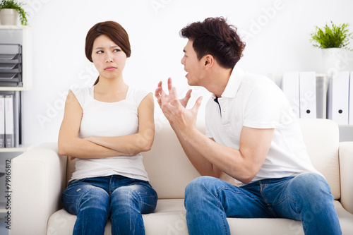 Angry young couple sitting on the sofa