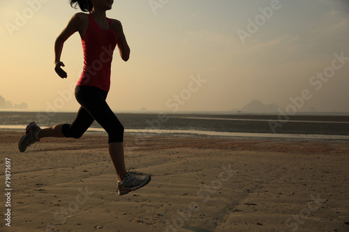  young healthy lifestyle woman running at sunrise beach