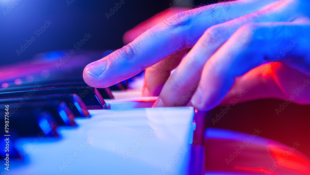 Naklejka premium hands of musician playing keyboard in concert with shallow depth