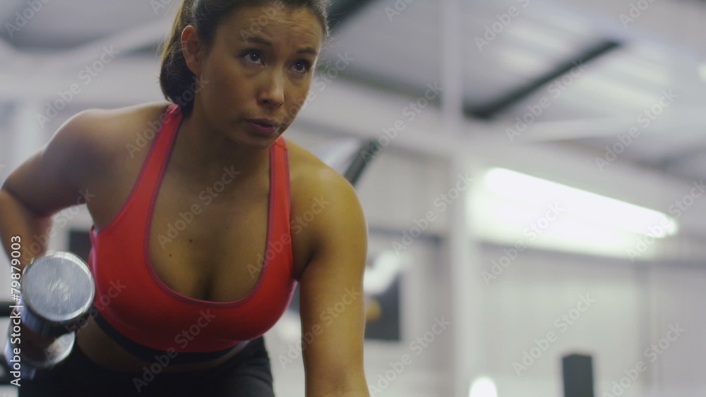 Close up slow motion woman using free weights in gym Close up slow motion woman using free weights in gym