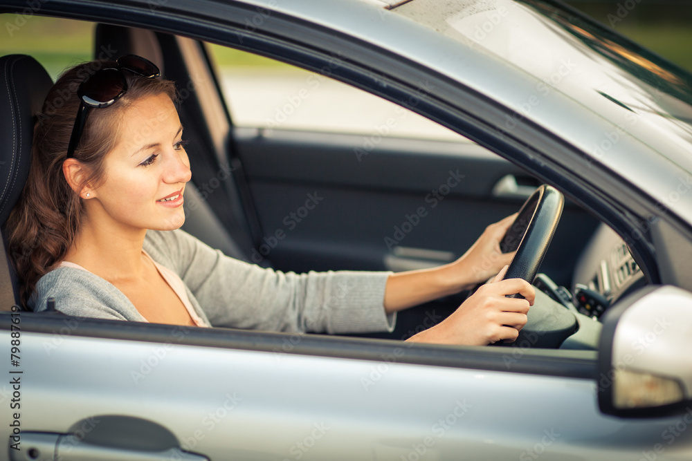 Pretty young woman driving her new car (color toned image; shal Pretty young woman driving her new car (color toned image; shal