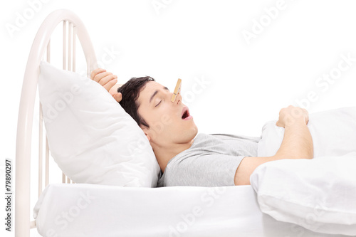 Man sleeping with a clothespin on his nose