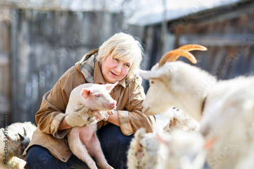 Foto female farmer holding a small pig