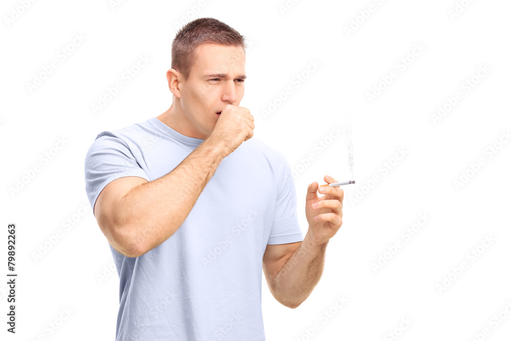 Young man smoking a cigarette and coughing