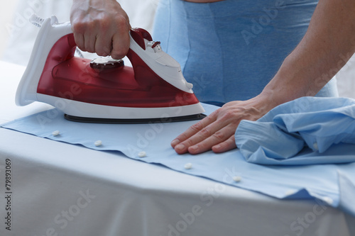 Man ironing his shirt photo