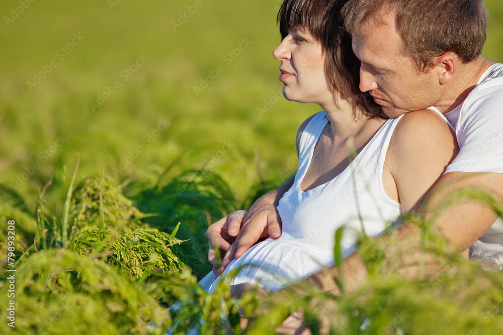 Happy parents are relaxing in grass Happy parents are relaxing in grass