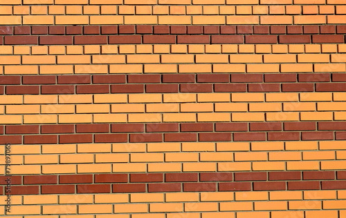 Brick wall painted in stripes of brown and yellow background