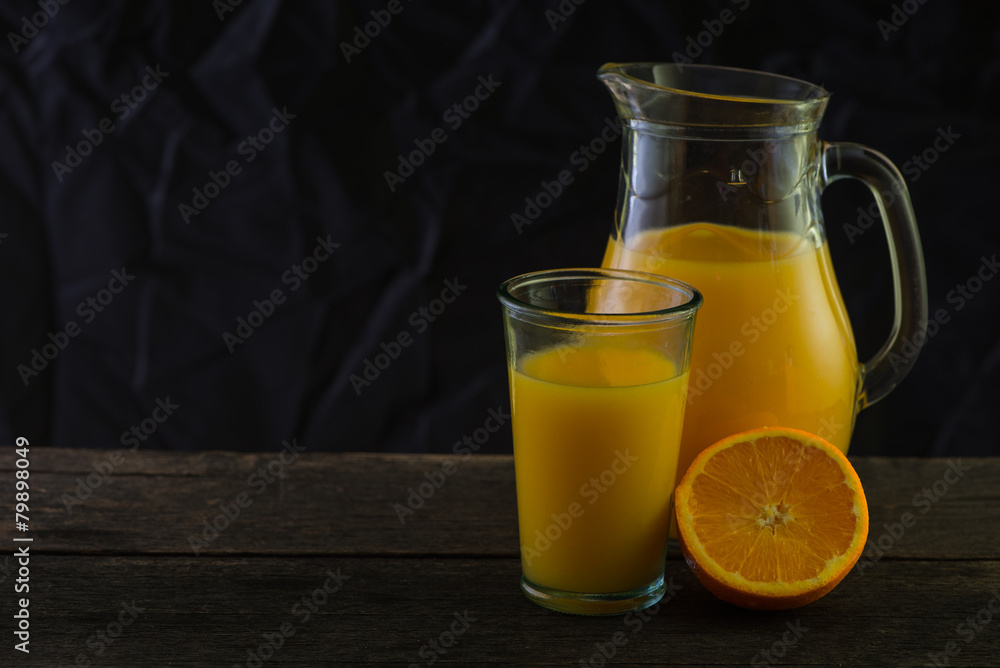 Jug and glass with fresh orange juice, still life art on dark ba Jug and glass with fresh orange juice, still life art on dark ba