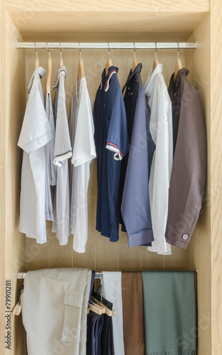 wooden closet with clothes hanging
