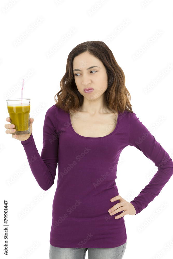 Woman looking to her glass of green smoothie with a bitter face Woman looking to her glass of green smoothie with a bitter face