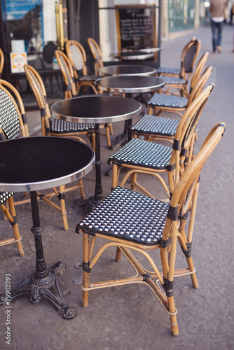 Round tables and wicker chairs in a cafe in Paris, France.